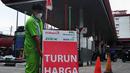Petugas membawa papan informasi harga turun di SPBU di Jakarta, Selasa (3/1/2023).Selain menurunkan harga Pertamax, pemerintah juga menurunkan harga Pertamax Turbo (RON 98) yang turun harga dari Rp15.200 per liter menjadi Rp14.180 per liter sejak penyesuaian harga terakhir. (Liputan6.com/Angga Yuniar)