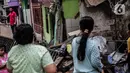 Warga melihat rumah yang roboh akibat pembuatan saluran air di Jalan Kayu Manis IX, Matraman, Jakarta Timur, Senin (16/12/2019). Pelaksana pembangunan saluran air akan bertanggung jawab memperbaiki rumah yang telah lapuk fondasinya tersebut mulai Senin. (Liputan6.com/Faizal Fanani)