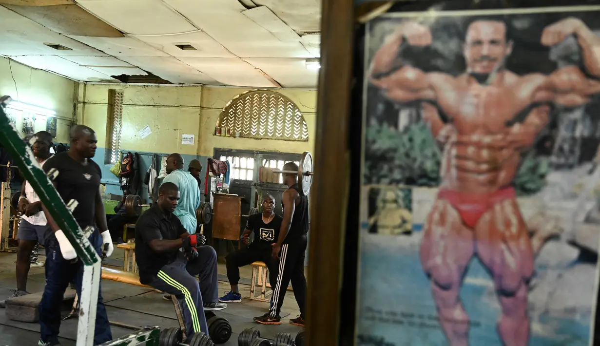 Sejumlah binaragawan mengangkat beban saat berolahraga di gym Kaloleni, di Nairobi, Kenya (9/1). (AFP Photo/Simon Maina)