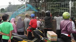 Warga menyaksikan alat berat mengeksekusi bangunan rumah milik warga yang terdampak proyek Jalan Tol Cijago Seksi II sepanjang 5,5 km di kawasan Kukusan, Depok, Jawa Barat, Rabu (12/12). (Liputan6.com/Immanuel Antonius)