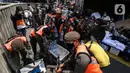 Aparat gabungan mengangkut dagangan pedagang yang berjualan di trotoar di kawasan Tanah Abang, Jakarta, Minggu (2/5/2021). Selain merazia barang dagangan pedagang, aparat gabungan juga menegur warga yang tidak menerapkan protokol kesehatan. (Liputan6.com/Johan Tallo)