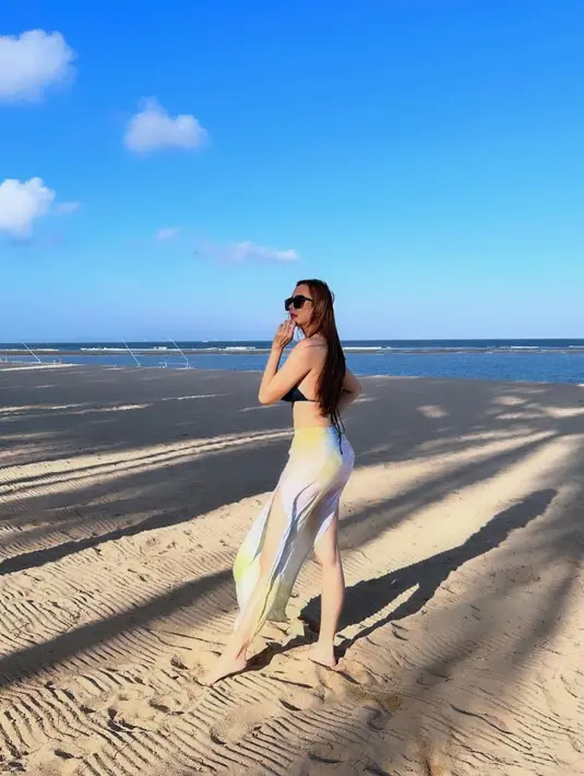 Tetap pede berbikini saat ke pantai, Aura Kasih memadukannya dengan cover up skirts warna cerah. [Instagram/aurakasih]