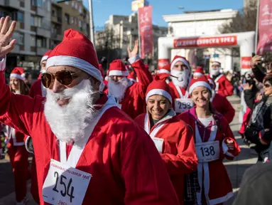 Seorang pria berpakaian Santa Claus melambaikan tangan saat mengikuti perlombaan lari tradisional Santa Claus Tahun Baru di Skopje, (24/12) (AFP Photo / Robert Atanasovki)