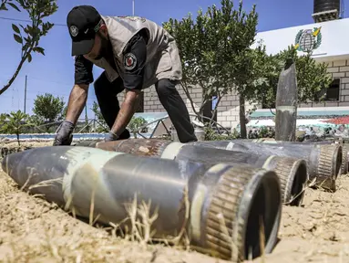 Seorang ahli bahan peledak Hamas menunjukkan proyektil yang tidak meledak setelah konflik Mei 2021 dengan Israel di kantor polisi setempat di Khan Yunis, Jalur Gaza, Sabtu (5/6/2021). Perang 11 hari antara Hamas dan Israel menewaskan 254 orang Palestina dan 12 orang Israel. (MAHMUD HAMS/AFP)