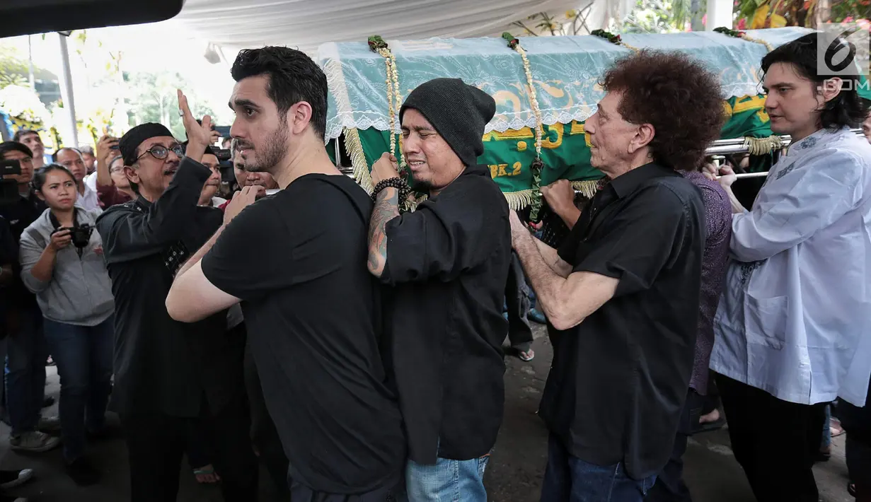Fachri Albar (kiri) bersama Achmad Albar (dua kanan) dan para kerabat membawa jenazah Faldy Albar untuk disalatkan di Cinere, Depok, Jawa Barat, Kamis (30/8). Faldy Albar merupakan putra ketiga Ahmad Albar. (Liputan6.com/Faizal Fanani)