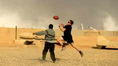 Tentara AS berusaha menangkap bola saat bermain American Football pada Thanksgiving di dalam pangkalan militer AS di Qayyara, selatan Mosul, Irak (24/141). (REUTERS/Thaier Al-Sudani)