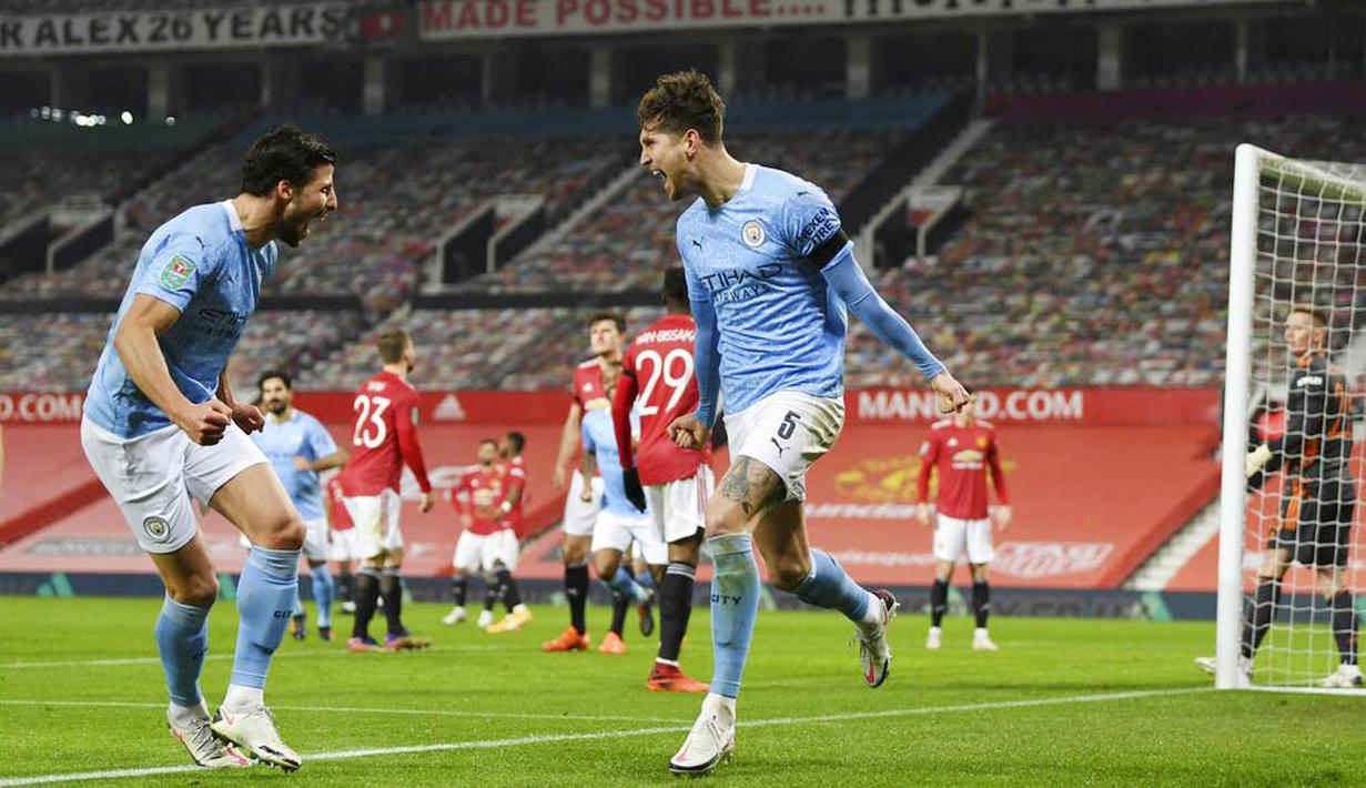 Pemain Manchester City, John Stones, melakukan selebrasi usai mencetak gol ke gawang Manchester United pada laga Piala Liga Inggris di Stadion Old Trafford, Rabu (6/1/2021). City menang dengan skor 2-0. (Shaun Botterill/Pool via AP)