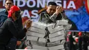 Seorang anggota polisi menunjukkan kekuatan fisiknya dengan mematahkan balok beton dalam sebuah upacara yang diadakan untuk memperingati hari jadi ke-78 Kepolisian Republik Indonesia di Banda Aceh pada 1 Juli 2024. (CHAIDEER MAHYUDDIN/AFP)