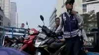 Satu persatu sepeda motor yang parkir sembarangan di kawasan Thamrin City, Jakarta Pusat dinaikkan petugas ke atas truk.