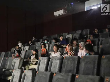 Anak-anak bersiap menyaksikan film di Indiskop atau Bioskop Rakyat di dalam Pasar Jaya Teluk Gong, Penjaringan, Jakarta Utara, Rabu (3/6/2019). Bioskop rakyat ini masih dalam tahap uji coba yang nantinya akan diresmikan pada tanggal 10 Juli 2019 mendatang. (Liputan6.com/Faizal Fanani)