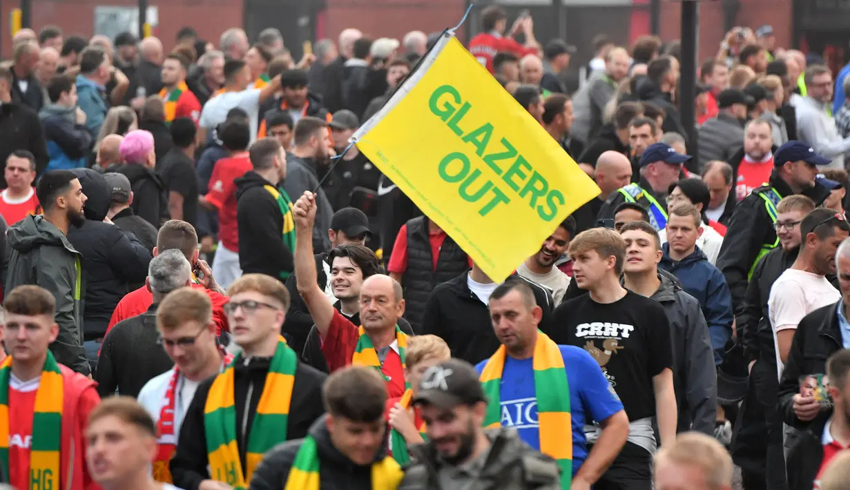 Para pengunjuk rasa berbaris menuju stadion Old Trafford untuk berdemonstrasi menentang pemilik Manchester United menjelang pertandingan Liga Inggris melawan Liverpool di Old Trafford, pada Senin, 22 Agustus 2022. Protes besar-besaran oleh penggemar MU sebelum kick-off ditujukan kepada pemilik klub, keluarga Glazer. (Foto oleh ANTHONY DEVLIN / AFP)