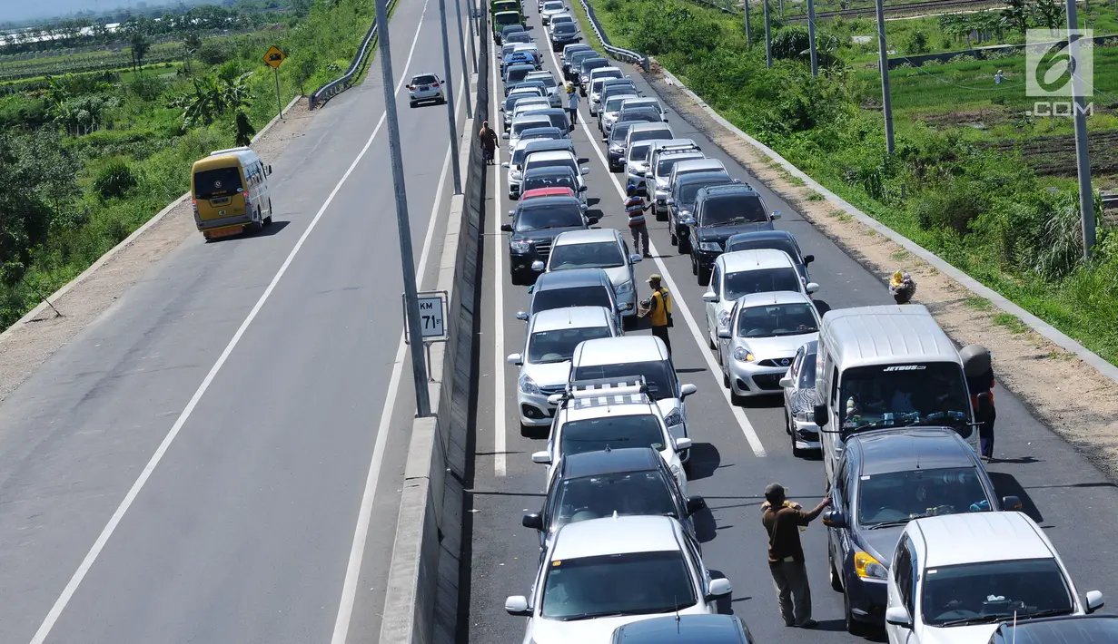 Pedagang menjajakan makanan ringan jelang Simpang Tiga Keluar Tol Brebes, Jawa Tengah, Sabtu (23/12). Memanfaatkan kepadatan arus libur panjang Natal 2017, pedagang menjajakan dagangan di Simpang Tiga Keluar Tol Brebes. (Liputan6.com/Helmi Fithriansyah)