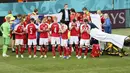 Para pemain Denmark membuat brikade untuk menutupi Christian Eriksen yang jatuh pingsan saat melawan Finlandia pada laga Piala Eropa di Stadion Parken (12/6/2021). (AFP/Wlofgang Ratttay)