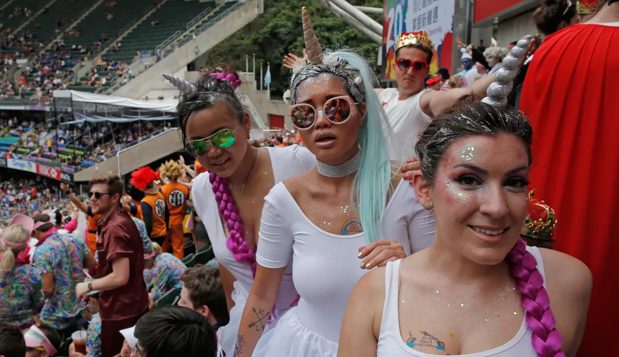 Tiga fans wanita mengenakan kostum Unicorn saat menyaksikan pertandingan RugbY Sevens di Hong Kong (8/4). Para wanita yang  ini hadir mengenakan pakaian dan atribut unik demi mendukung tim kesayangannya. (AP Photo / Kin Cheung)