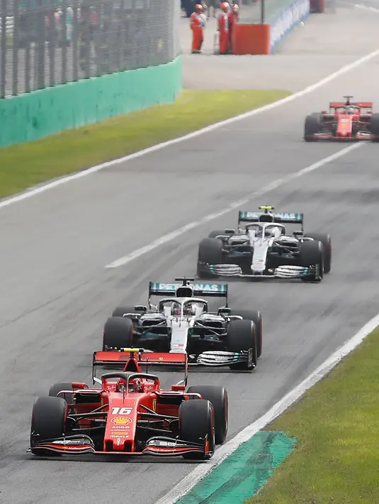 Pembalap Ferrari Charles Leclerc (depan) dikejar dua pembalap Mercedes Lewis Hamilton dan Valtteri Bottas dalam balapan F1 GP Italia 2019 di Sirkuit Monza, Minggu (8/9/2019). Leclerc juara setelah pertarungan alot melawan Lewis Hamilton dan Valtteri Bottas. (AP Photo/Antonio Calanni)