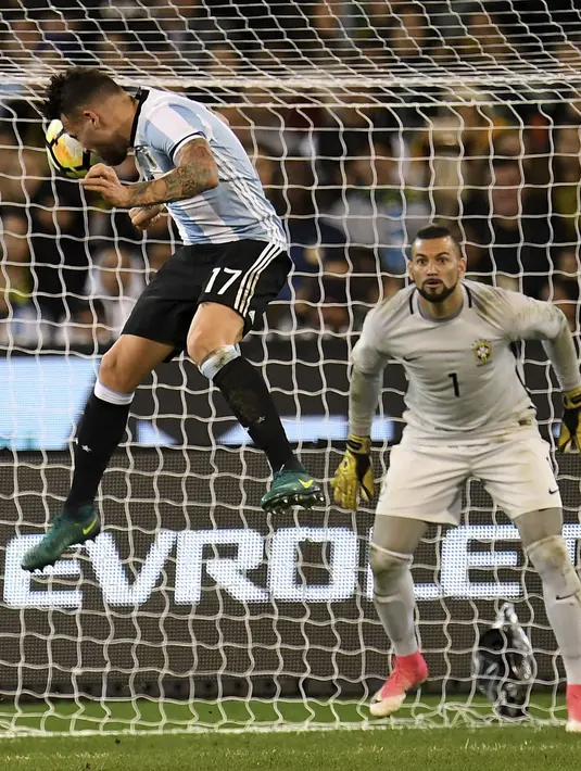 Pemain Argentina, Nicolas Otamendi menyundul bola ke arah gawang Brasil pada laga persahabatan di Melbourne Cricket Ground, Melbourne, Australia, (9/6/2017). (Joe Castro/AAP Image via AP)