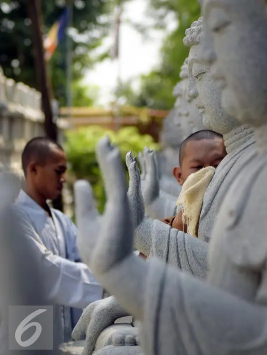 Dua orang bhiksu membersihkan patung di  Vihara Mahavira Graha Semarang , Sabtu ( 21/5/2016). Terdapat 120 patung Budha di Vihara Mahavira Graha Semarang. (Gholib)