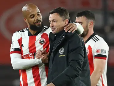 Striker Sheffield United, David McGoldrick (kiri) menghibur manajer interim, Paul Heckingbottom usai kemenangan 1-0 atas Brighton and Hove Albion dalam laga lanjutan Liga Inggris 2020/2021 pekan ke-33 di Bramall Lane, Sheffield, Sabtu (24/4/2021). (AFP/Tim Goode/Pool)