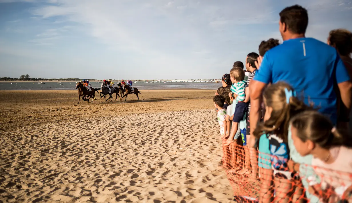 Sejumlah joki memacu kuda mereka pada lomba pacuan kuda di sepanjang pantai di Sanlucar de Barrameda, Spanyol pada 11 Agustus 2019. Balap kuda di tepi pantai ini merupakan acara tahunan yang telag berlangsung selama lebih dari 140 tahun. (AP Photo/Javier Fergo)