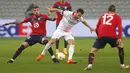 Gelandang AC Milan, Hakan Calhanoglu (kanan) membawa bola dari kawalan pemain Lille, Xeka pada pertandingan lanjutan Grup H Liga Europa di stadion Stade Pierre Mauroy di Villeneuve d'Ascq, Prancis, Kamis (26/11/2020). AC Milan bermain imbang 1-1 atas Lille. (AP Photo/Michel Spingler)