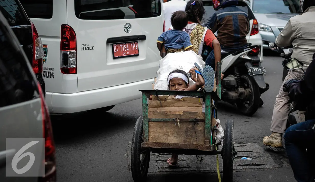 Seorang ibu membawa kedua anaknya mencari barang bekas dengan gerobak melintasi kawasan Wahid Hasyim, Jakarta, Kamis (6/10). Jumlah penduduk miskin di DKI Jakarta meningkat menjadi 384.300 orang atau 3,75% dari total penduduk. (Liputan6.com/Faizal Fanani)