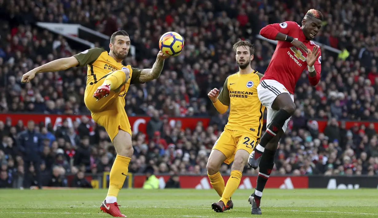 Pemain Brighton, Shane Duffy menghalau bola dari kejaran pemain Manchester United, Paul Pogba pada lanjutan Premier League di Old Trafford, Manchester,(25/11/2017). Manchester United menang tipis 1-0. (Martin Rickett/PA via AP)