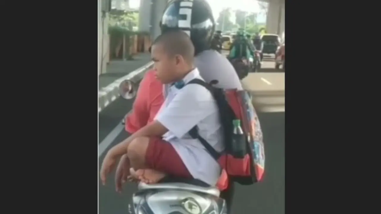 Bocah SD duduk bersila saat diboceng motor. (capture/istimewa)