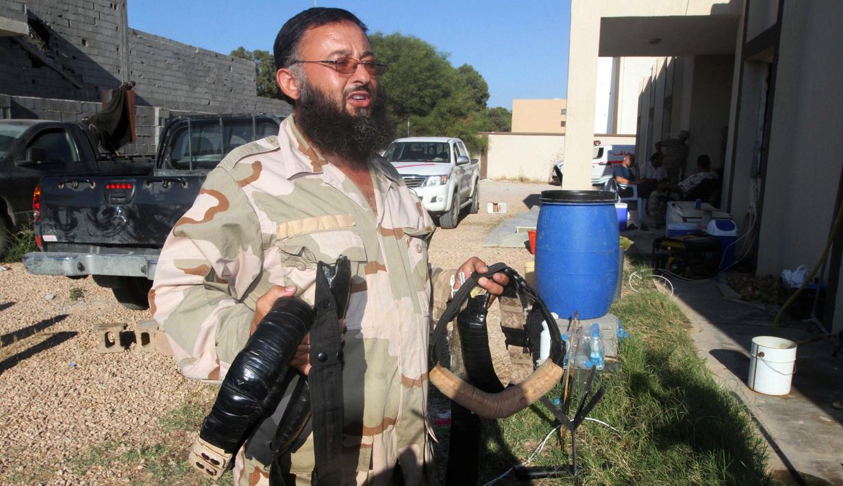 Anggota militer Libya membawa bom rakitan milik militan ISIS yang ditemukan di Sirte (5/9). Bom rakitan milik militan ISIS ini memiliki komponen kabel yang sulit untuk dijinakkan. (REUTERS/Hani Amara)