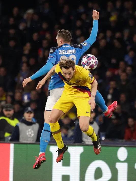 Pemain Barcelona Ivan Rakitic (depan) berebut bola dengan pemain Napoli Piotr Zielinsk pada pertandingan babak 16 besar Liga Champions di San Paolo Stadium, Naples, Italia, Selasa (25/2/2020). Pertandingan berakhir dengan skor 1-1. (Alfredo Falcone/Andrew Medichini)