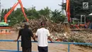 Warga melihat tumpukan sampah yang didominasi potongan bambu dan botol plastik menumpuk di Pintu Air Manggarai, Jakarta, Jumat (26/4). Sampah ini terbawa arus sungai Ciliwung akibat curah hujan yang tinggi di kawasan Bogor dan sekitarnya, Kamis (25/4). (Liputan6.com/Helmi Fithriansyah)