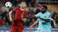 Pemain AS Roma Edin Dzeko berebut bola dengan pemain Barcelona, Samuel Umtiti pada laga leg kedua perempat final Liga Champions di Stadion Olimpico, Selasa (10/4). AS Roma sukses menggilas Barcelona 3-0 untuk merebut tiket semifinal. (AP/Gregorio Borgia)