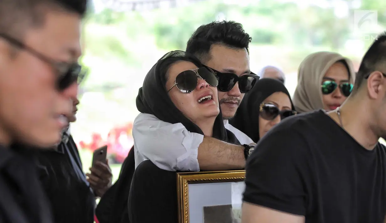 Tangis adik Olla Ramlan, Cynthia Ramlan saat proses pemakaman sang ayahanda, Muhammad Ramlan di TPU Tanah Kusir, Jakarta, Selasa (5/6). Ayahanda Olla Ramlan meninggal di usia 72 tahun akibat kanker dan liver yang dideritanya. (Liputan6.com/Faizal Fanani)