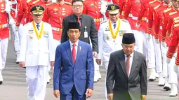 Presiden Joko Widodo atau Jokowi (kiri) didampingi Wakil Presiden Jusuf Kalla berjalan dari Istana Merdeka menuju Istana Negara saat akan melantik Gubernur dan Wakil Gubernur terpilih Maluku Utara Abdul Gani Kasuba dan Al Yasin, Jakarta, Jumat (10/5/2019). (Liputan6.com/Angga Yuniar)