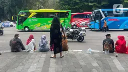 Sejumlah tamu menunggu bus yang akan mengangkut mereka menuju resepsi pernikahan putra bungsu Presiden Jokowi, Kaesang Pangarep dan Erina Gudono dari Stadion Manahan, Solo, Jawa Tengah, Minggu (11/12/2022).  Sejumlah tamu juga ada yang diantar dengan becak dan andong menuju Mangkunegaran. (Liputan6.com/Herman Zakharia)