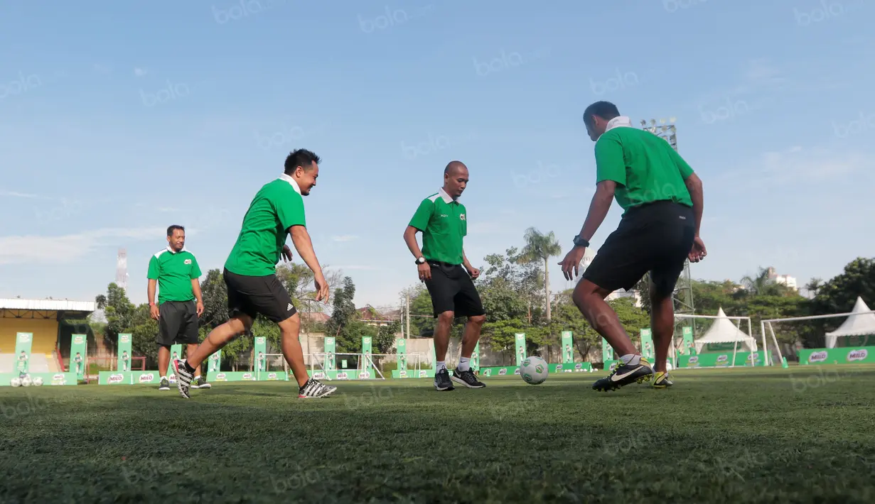 Kurniawan Dwi Yulianto dan para pelatih lainnya melakukan pemanasan sebelum berbagi tips untuk siswa Sekolah Dasar pada ajang Milo Football Clinic Day, Minggu (30/10/2016) di Simprug. (Bola.com/Nicklas Hanoatubun)