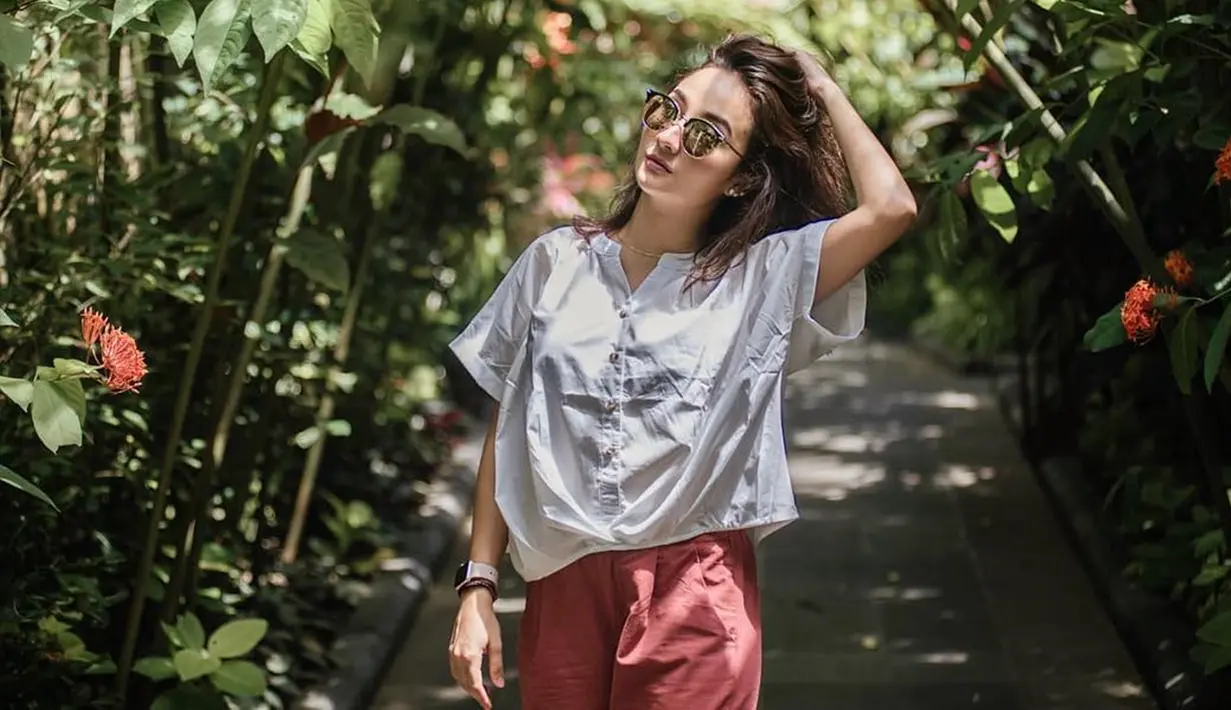 Wanita berdarah Jerman ini lebih suka menggunakan blouse dan celana kain untuk outfit liburannya. Selain senang dengan gaya casual dengan perpaduan warna basic, Naomi juga sering mengandalkan mix and match fashion dengan warna pastel.(Liputan6.com/IG/@naonomnom)