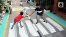 Anak-anak bermain di atas lukisan tiga dimensi (3D) di Jalan Perumahan Bojong Depok Baru 1, RT 03/RW 19 Bojonggede, Bogor, Jawa Barat, Selasa (3/8/2020). Dalam rangka menyambut HUT ke-75 RI, warga berbenah memperindah lingkungan dengan melukis 3D pada jalan. (merdeka.com/Arie Basuki)