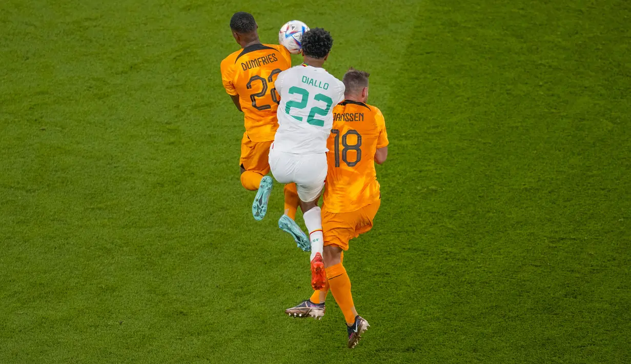 Pemain Senegal, Abdou Diallo berebut bola dengan dua pemain Belanda, Denzel Dumfries dan Vincent Janssen pada pertandingan grup A Piala Dunia 2022 Qatar di Stadion Al Thumama di Doha, Qatar, Senin (21/11/2022). Belanda menang atas Senengal dengan skor 2-0. (AP Photo/Thanassis Stavrakis)