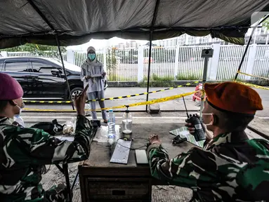 Tenaga kesehatan melapor kepada penjaga saat mengantarkan pasien positif Covid-19 di salah satu pintu masuk Runah Sakit Darurat (RSD) Wisma Atlet, Kemayoran, Jakarta, Minggu (30/5/2021). (merdeka.com/Iqbal S. Nugroho)