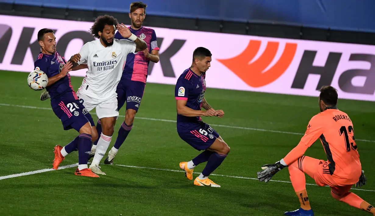 Bek Real Madrid, Marcelo (kedua kiri) menantang kiper Valladolid, Roberto Jimenez pada lanjutan La Liga Spanyol di stadion Alfredo, Rau (30/9/2020). Real Madrid menekuk Real Valladolid denga skor 1-0. (PIERRE-PHILIPPE MARCOU / AFP)