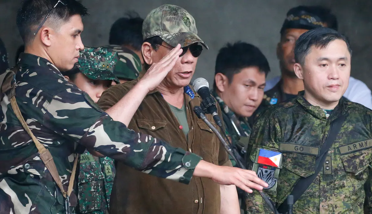 Presiden Filipina, Rodrigo Duterte memberi hormat kepada pasukan saat mengumumkan pembebasan kota Marawi di Filipina (17/10). (AP Photo/Bullit Marquez)