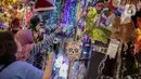 Calon pembeli memilih pernak-pernik Natal yang dijual di Pasar Asemka, Glodok, Jakarta, Kamis (12/12/2019). Umat Kristiani mulai mendatangi pusat perbelanjaan untuk berburu pernak-pernik penghias rumah dan pohon Natal. (Liputan6.com/Faizal Fanani)