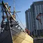 Seorang anak melompat dari atas kapal yang tengah bersandar di Pelabuhan Sunda Kelapa, Jakarta, Senin (6/7/2020). Mereka memanfaatkan waktu libur sekolah dengan bermain lompatan sambil berkumpul bersama teman-teman. (Liputan6.com/Fery Pradolo)