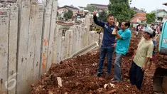Bakal Cagub DKI, Agus Harimurti Yudhoyono mendengarkan penjelasan warga saat menyusuri pinggiran Sungai Ciliwung yang merupakan lokasi proyek normalisasi, di kawasan Bukit Duri, Jakarta, Kamis (20/10). (Liputan6.com/Gempur M Surya)