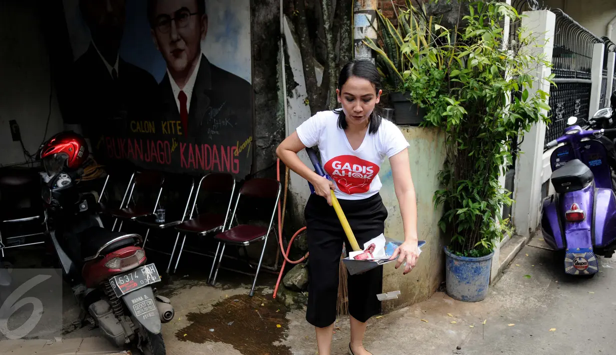 Gadis Ahok terlihat membersihkan sampah di kawasan Cipete, Jakarta Selatan, Senin (26/12). Aksi ini dilakukan agar masyarakat di Jakarta bisa lebih peduli lagi tentang pentingnya kebersihan lingkungan tempat tinggalnya. (Liputan6.com/Gempur M Surya)