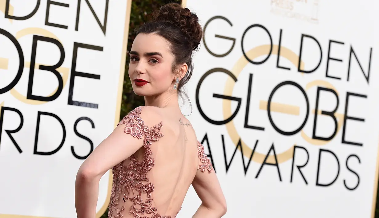 Aktris Lily Collins menghadiri ajang Golden Globe Awards yang digelar di Hotel Beverly Hilton, California, Minggu (8/1). Lily Collins tampil menawan bak princess dengan gaun haute couture cantik berwarna salem. (Jordan Strauss/Invision/AP)