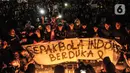 Massa yang tergabung dalam Ultras Garuda Jakarta mengikuti aksi menyalakan lilin dan tabur bunga untuk korban kerusuhan Stadion Kanjuruhan Malang di depan Stadion Gelora Bung Karno (GBK), Jakarta, Minggu (2/10/2022). Aksi tersebut sebagai aksi solidaritas antar suporter dan bentuk keprihatinan atas tragedi kerusuhan suporter sepak bola di Stadion Kanjuruhan Malang. (merdeka.com/Iqbal S Nugroho)