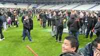 Ribuan Penonton berhamburan di lapangan stadion Stade de France saat menyaksikan pertandingan antara Prancis melawan Jerman di Saint-Denis, Paris, (13/11). Serangan bom terjadi di dekat stadion Stade de France Prancis. (AFP PHOTO/MIGUEL MEDINA)