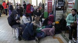 Pengungsi Ukraina berkumpul di stasiun kereta api di Przemysl, Polandia tenggara, pada Rabu (23/3/2022). Polandia telah menerima lebih dari 2 juta pengungsi Ukraina sejak invasi Rusia pada 24 Februari lalu. (AP Photo/Sergei Grits)