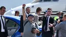 Legenda Argentina, Diego Maradona mengepalkan tangan ke udara setibanya di bandara Brest, Senin (16/7). Maradona mendarat di Belarusia untuk menjalani tugas barunya sebagai presiden klub sepak bola Dinamo Brest. (AFP PHOTO / Sergei GAPON)